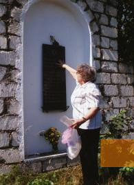 Bild:Dubossary, 2005, Eine Frau zeigt an einer Gedenktafel an die Namen ihrer erschossenen Verwandten, Stiftung Denkmal